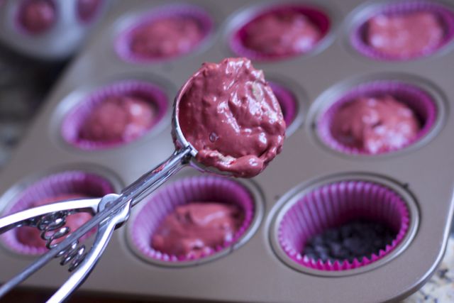 easy cheesecake recipe being put inside cupcake pan with a ice cream scoop