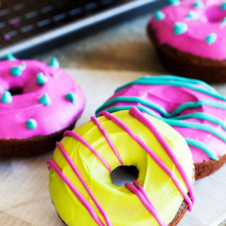 Baked chocolate cake doughnuts covered with a pop of colorful toppings make these Spooktacular Chocolate Doughnuts the perfect treat or your Halloween dessert table.