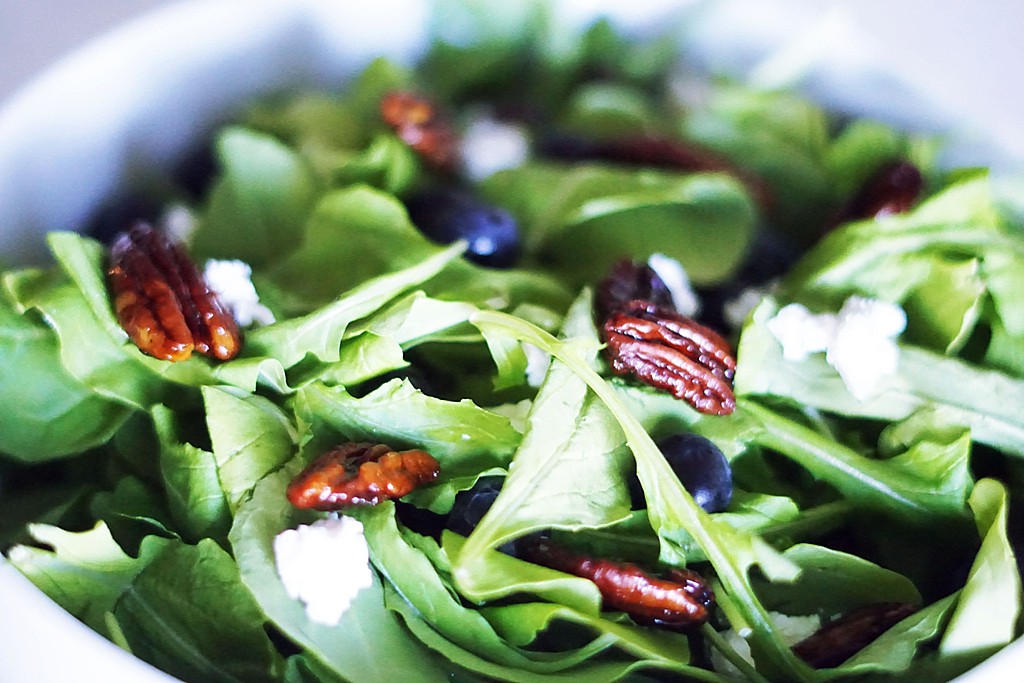 Satisfy your cravings with a delicious Caramelized Pecan Arugula Salad full of fresh blueberries, tangy goat cheese, and a drizzle of balsamic vinaigrette.