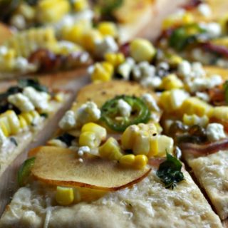 This sweet and spicy Peach Goat Cheese Jalapeño Pizza is a blissful twist on traditional grilled pizza! Seasonal peaches top this homemade crust along with goat cheese, corn, and caramelized jalapeños. You need this recipe in your life!
