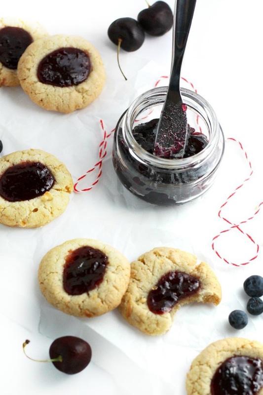 Celebrate this summer's patriotic holidays with these delightfully delicious and super simple Berry Coconut Thumbprint Cookies this year. Blueberry and cherry jam are served up on light and fluffy coconut cookies!