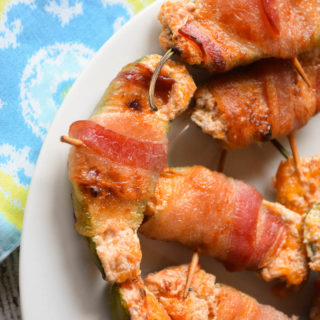 Sweet Bacon Wrapped Jalapeño Poppers are filled with cream cheese and cheddar cheese that has been blended with raspberry jam then wrapped in a blanket of salty bacon! This sweet heat treat will make crowds beg for more!