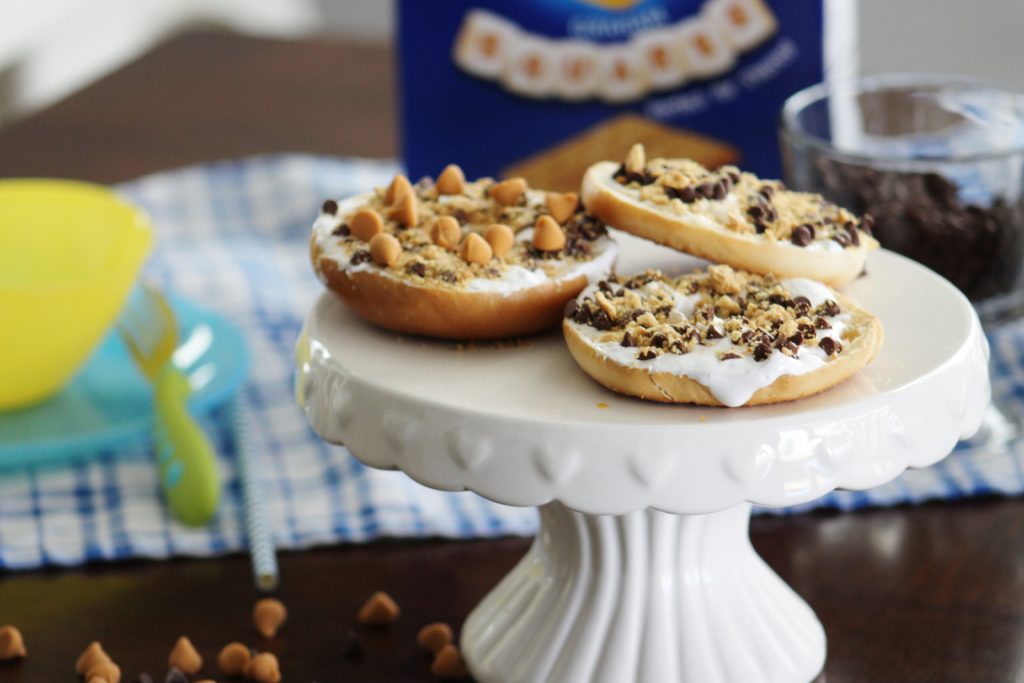 Make memories with your kids in the kitchen this summer when you let them get their hands sticky making these fun DIY S'mores Dessert Pizza Bagels. A unique twist on a traditional summer favorite treat!