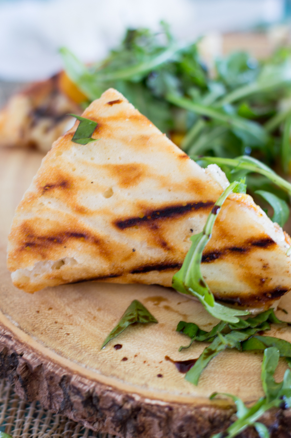 Fire up the grill and grab your best summer produce for this tasty Balsamic Glazed Grilled Peach Pizza recipe! Not only are we grilling the pizza, but the peaches too. Top it all off with spicy arugula and sweet balsamic glaze for the perfect summer-inspired pizza!
