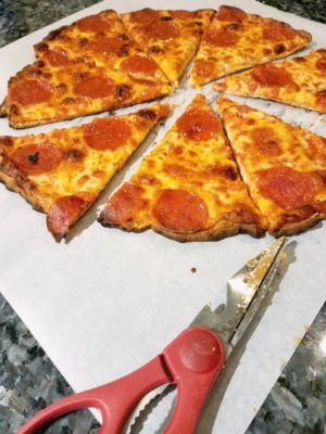 Ditch the messy pizza cutter and get perfect slices every time when you use this simple kitchen hack. Kitchen scissors are the best way to get a clean cut pizza without messing up your countertop.