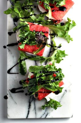 Impress your friends with this delectable, seasonal Balsamic Glazed Grilled Watermelon Stacked Salad recipe. The homemade balsamic glaze highlights the fresh flavors of the watermelon, arugula, and mozzarella.