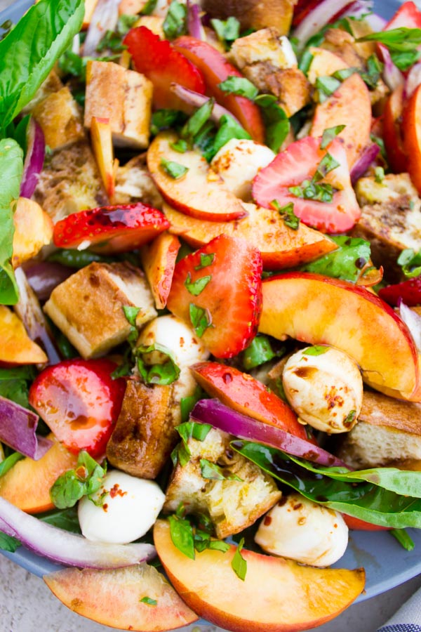 This Basil Peach Panzanella Salad is what farmers markets were made for! A tuscan salad with a twist, this simple, 20-minute recipe uses seasonal fruits and vegetables to create an international dish that's the perfect lunch, dinner side, or outdoor potluck.