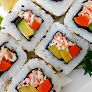Gather with friends to make these super simple California Sushi Rolls instead of going out for dinner. Rice, crab, avocado, carrots, and cucumber all wrapped in a nori roll.