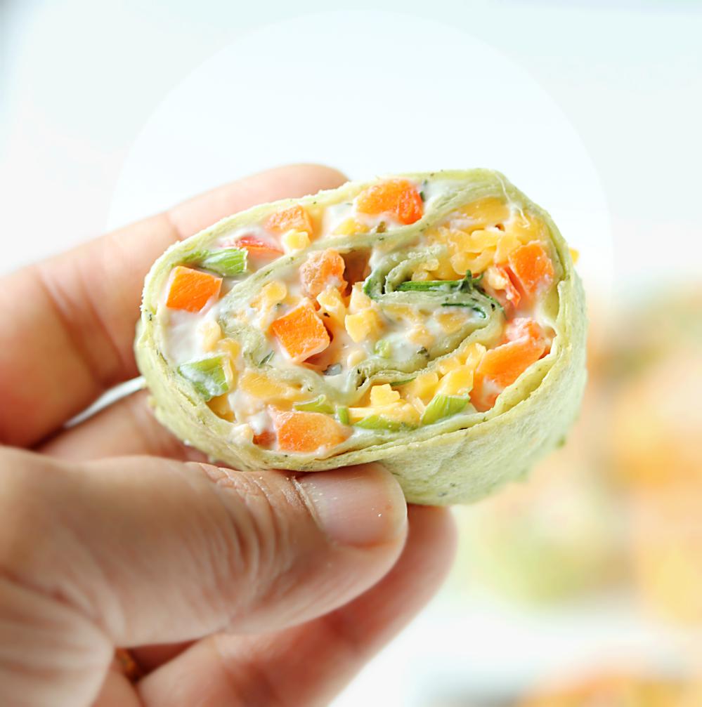 This Veggie Pinwheels Party Appetizer is perfect for tailgating, holiday get togethers, or potlucks. Farmers market veggies, ranch cream cheese spread, and shredded cheese wrapped in tortillas and cut into small bites for snacking!