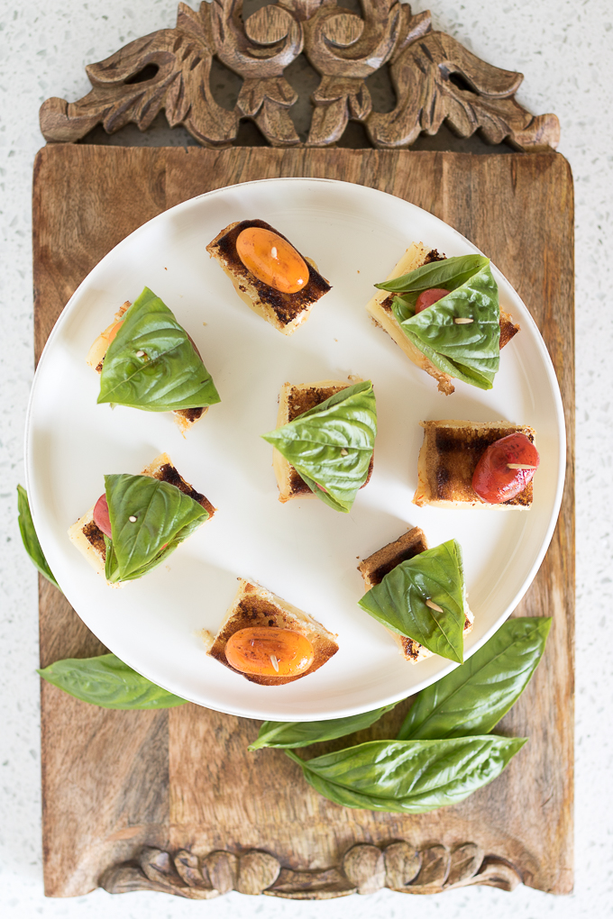 Grilled Cheese Tomato Bites topped with blistered sweet grape tomatoes and fresh basil leaves are an afternoon snack recipe you can't resist.