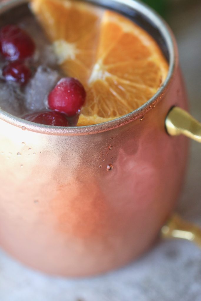 Looking for a refreshing holiday drink? Grab a copper mug and make these amazing Cranberry Orange Moscow Mules! Zesty, fresh and delicious; this cocktail is exactly what your party needs.
