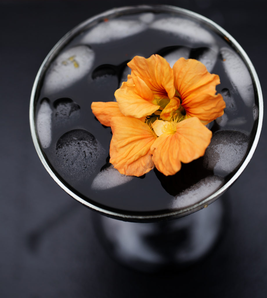 Celebrate the spookiest of holidays with this Mysterious Midnight Mango Margarita. Fresh mango purée, lime, and orange juice shaken with charcoal-infused tequila; this black-as-night cocktail is like the tropics in disguise!