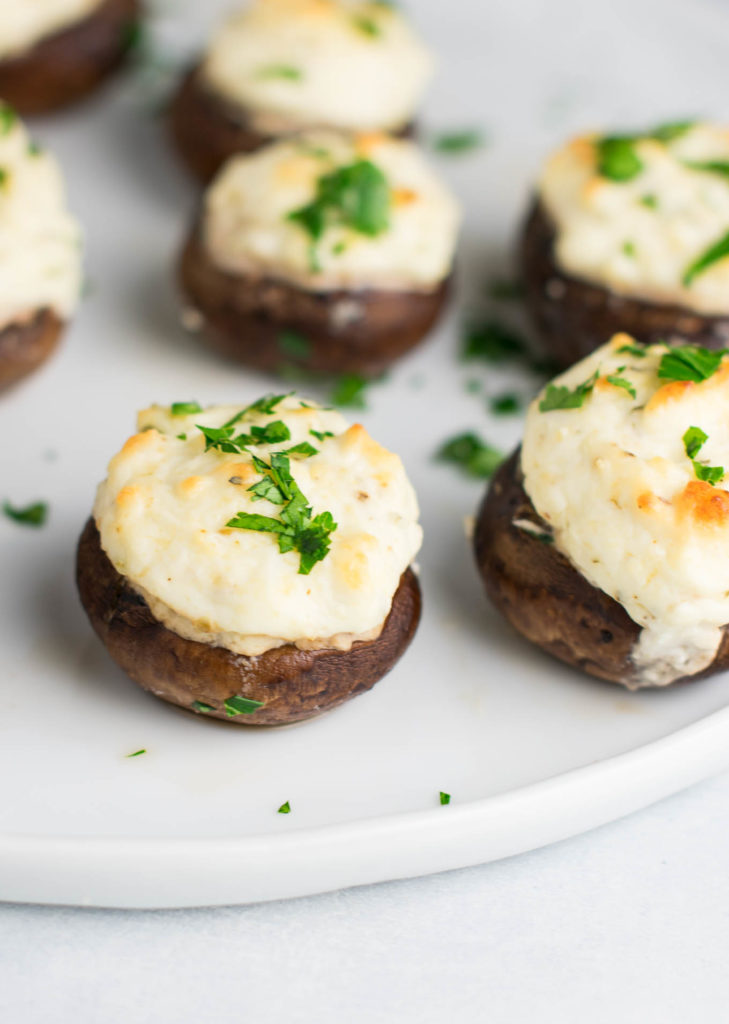 Tailgating and holiday parties just got more tasty with this Cheesy Stuffed Mushrooms recipe! All you need is baby bellas, cream cheese, parmesan cheese, greek yogurt, a few spices, and about 30 minutes.