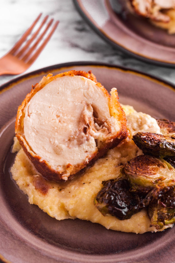 A fancy Chicken Cordon Bleu, stuffed with Havarti cheese and prosciutto, is the perfect cheat day meal. Pair it with cheesy polenta and roasted brussels sprouts and you’ve got comfort on a plate.