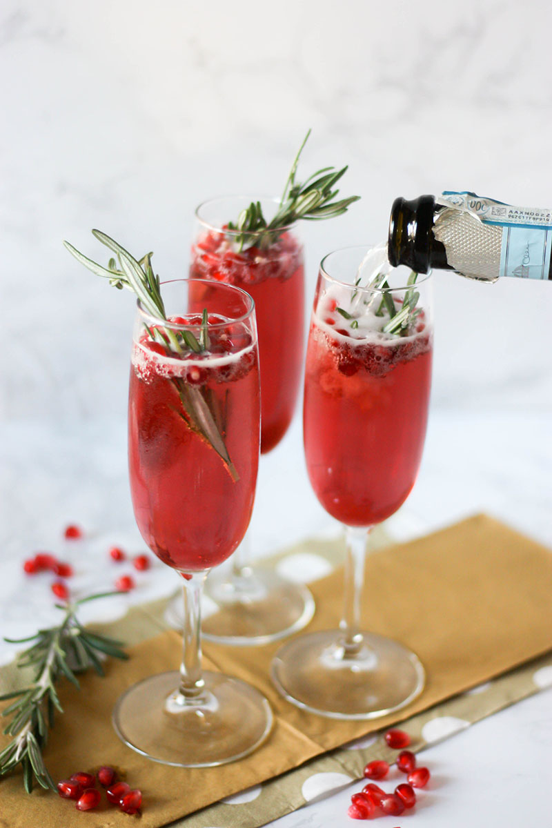 Everyone will love these Pomegranate Champagne Cocktails at your next winter get together! Made with homemade rosemary simple syrup, fresh pomegranate, and sparking pomegranate juice, these cocktails will help say cheers to whatever you're celebrating.