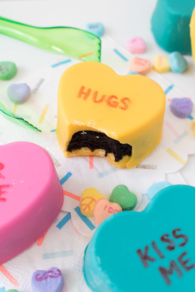 Cute and colorful, these Conversation Heart Cake Bombs are simple to make! Candy-coated chocolate cake with cute little sayings are the perfect way to show loved ones you care this Valentine's Day!