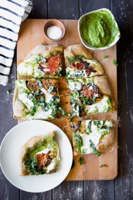 This Roasted Tomato Basil Pesto Pizza is perfect for pizza night at home. This healthier classic uses a whole wheat crust, herbed basil pesto, roasted heirloom tomatoes, and mozzarella to create a simple and satisfying vegetarian 30-minute meal.