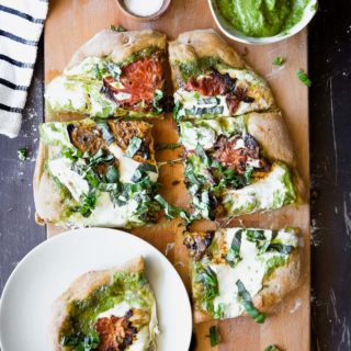This Roasted Tomato Basil Pesto Pizza is perfect for pizza night at home. This healthier classic uses a whole wheat crust, herbed basil pesto, roasted heirloom tomatoes, and mozzarella to create a simple and satisfying vegetarian 30-minute meal.