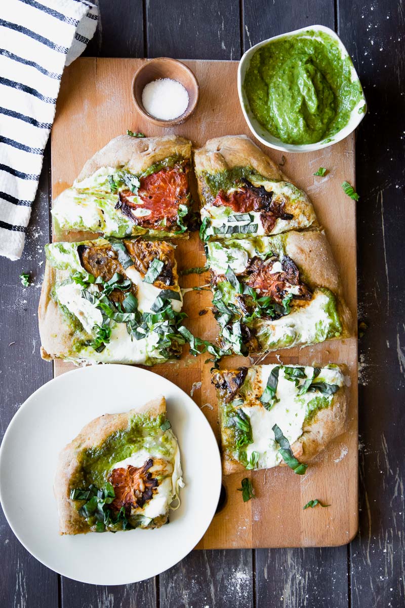 This Roasted Tomato Basil Pesto Pizza is perfect for pizza night at home. This healthier classic uses a whole wheat crust, herbed basil pesto, roasted heirloom tomatoes, and mozzarella to create a simple and satisfying vegetarian meal.