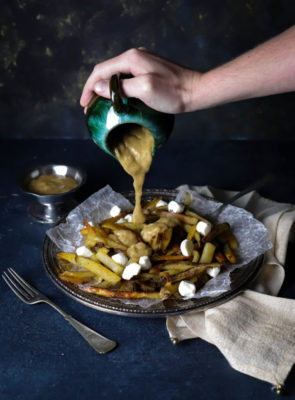 Authentic Canadian Classic Poutine is a traditional Canadian appetizer that's so hearty, it can be served as a meal. Baked seasoned fries topped with cheese curds and homemade gravy is just the indulgence you need for cheat day, parties, or happy hour at home!