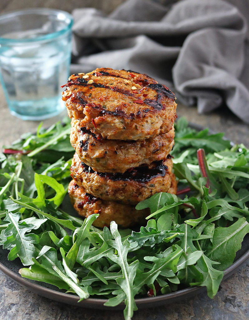 Outdoor grilling season is here and it's time to make these easy Grilled Honey Chili Chicken Burgers. Perfect for meal prep for the week, these sweet and spicy burgers are perfect for entertaining or a weeknight meal. Serve on buns or in a salad!