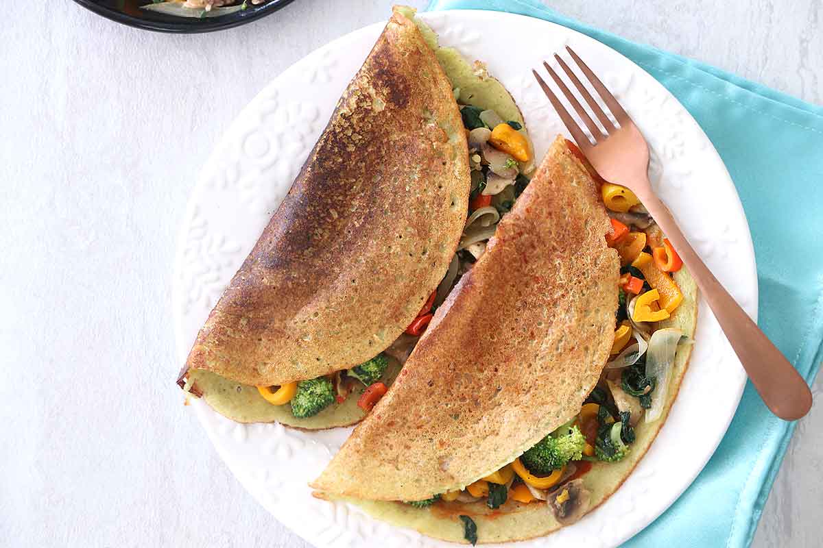 Sautéed Veggie Stuffed Lentil Crepes, aka Veggie Stuffed Moong Dal Chilla, are a cheap healthy meal to enjoy as a nutritious breakfast. This popular Indian vegetarian dish gets protein from the Moong Dal Lentils and vitamins and minerals from the mixed veggies.