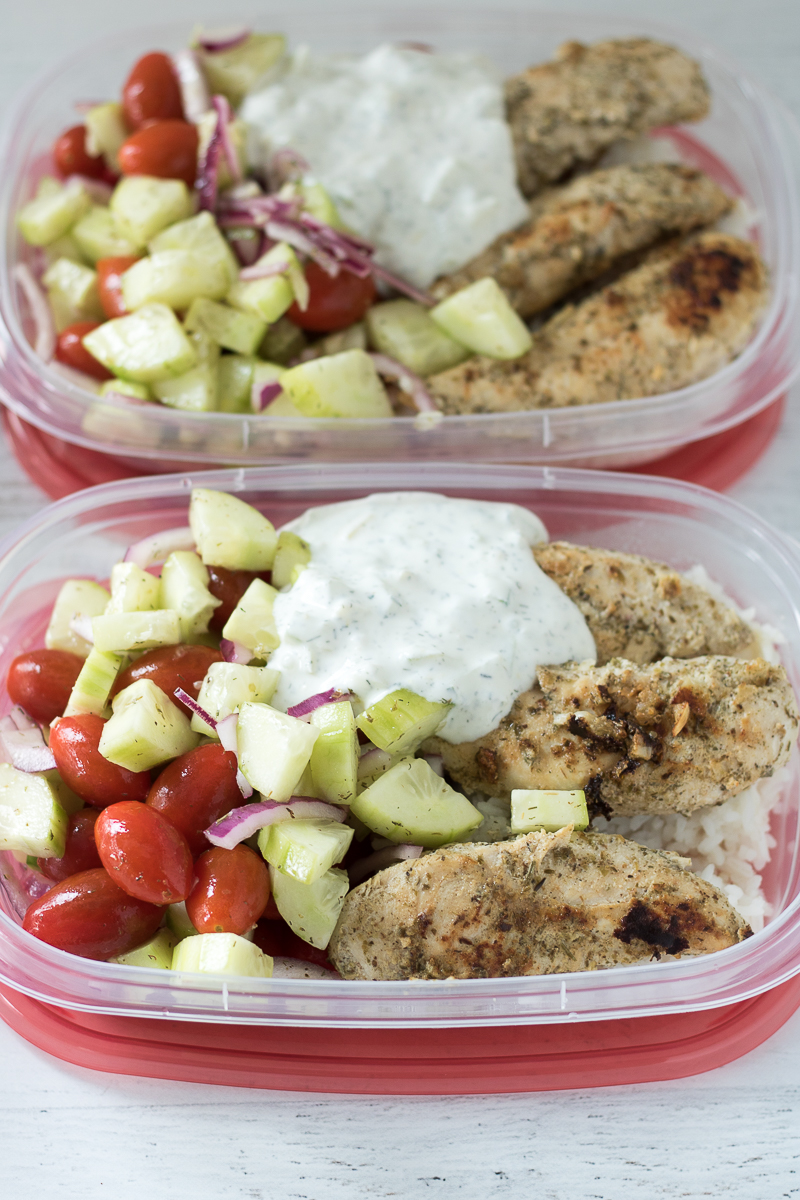 These Greek Chicken Bowls are great for easy meal prep. This cheap healthy meal includes chicken over rice with Tzatziki sauce and a grape tomato-cucumber salad. A 30-minute meal that's perfect for lunchtime or dinner!