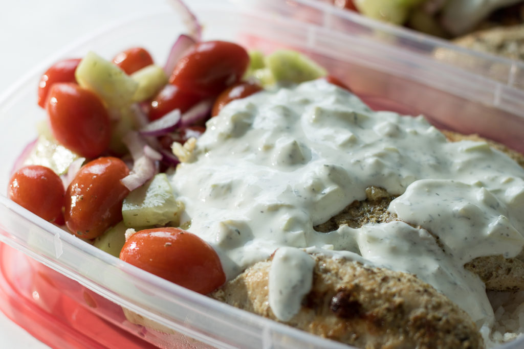 These Greek Chicken Bowls are great for easy meal prep. This cheap healthy meal includes chicken over rice with Tzatziki sauce and a grape tomato-cucumber salad. A 30-minute meal that's perfect for lunchtime or dinner!