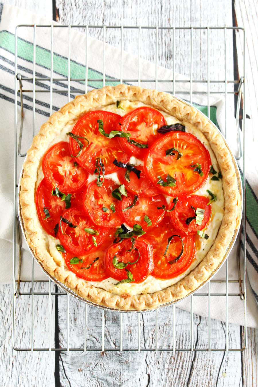 This beautiful Jersey Tomato 3-Cheese Tart is filled with a trio of cheeses and topped with fresh tomato slices and basil. It's the perfect vegetarian dish or party appetizer to make with fresh tomatoes from the farmers market or garden!