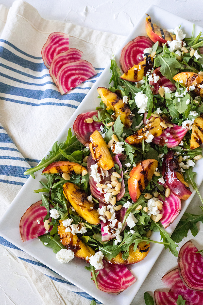 Outdoor grilling gets a fresh, farmers market makeover with this Grilled Stone Fruit Salad recipe. Ready in 15 minutes, light, and colorful, this picnic food is perfect for outdoor entertaining and summer celebrations!