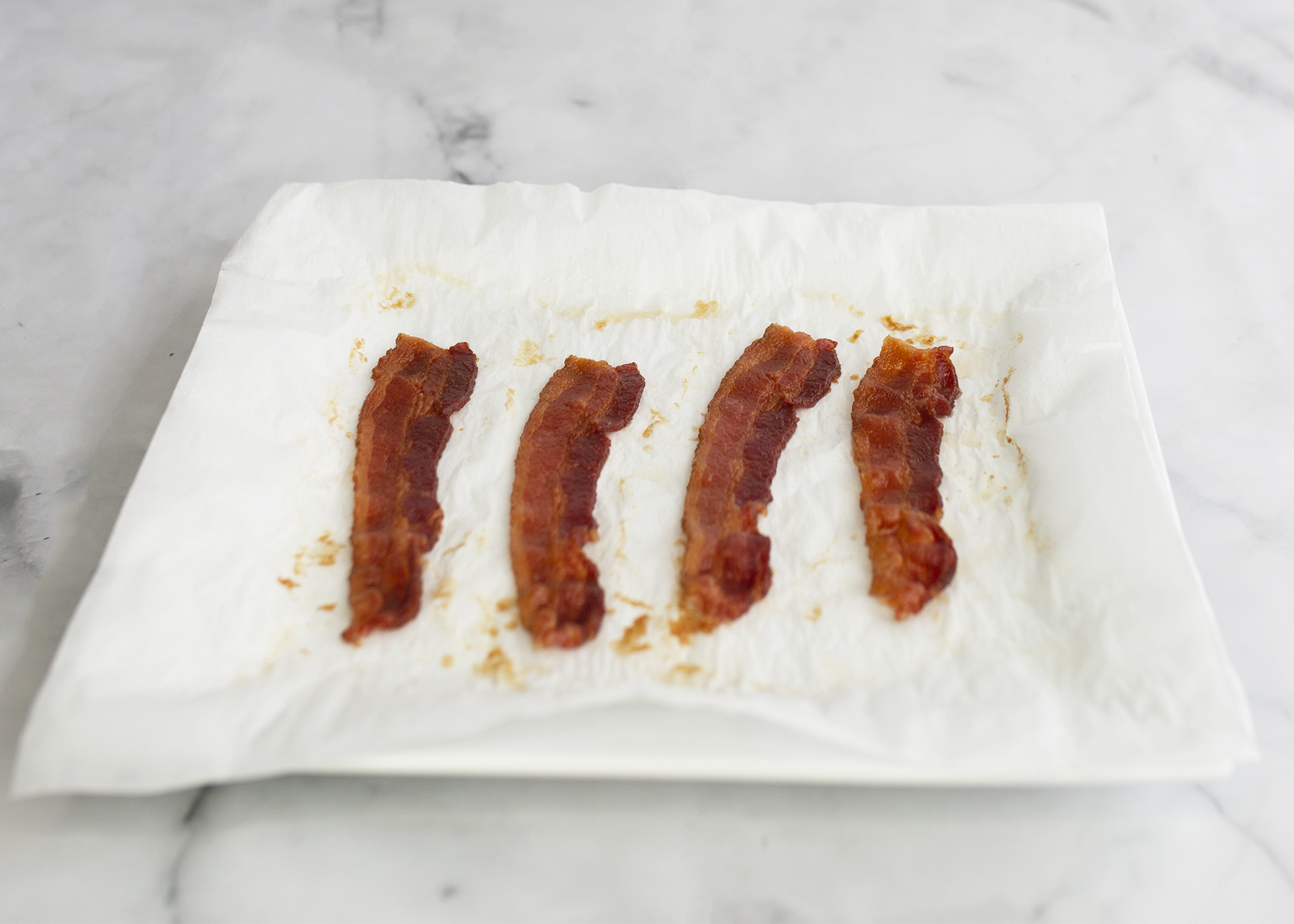 Love bacon, but hate the time and mess of making it? This handy kitchen hack is your saving grace. Enjoy your favorite protein source in all of your best recipes when you learn how to make 4-Minute Perfect Crispy Bacon with no mess!
