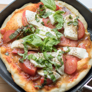 This Homemade Grilled Caprese Pizza is a vegetarian dish made from scratch. Topped with the fresh flavors of tomato, basil, and mozzarella on an easy homemade pizza crust, these single serve pizzas are perfect if you're cooking for two for date night.