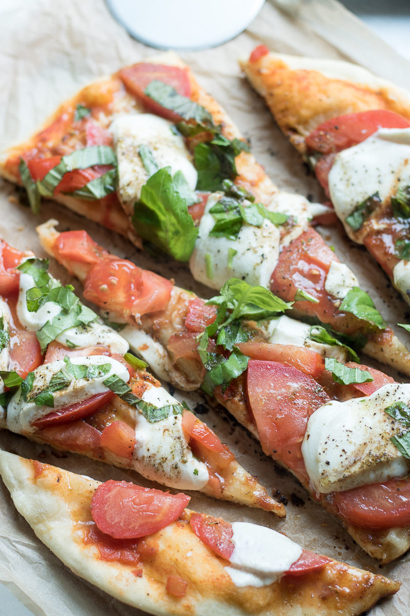 This Homemade Grilled Caprese Pizza is a vegetarian dish made from scratch. Topped with the fresh flavors of tomato, basil, and mozzarella on an easy homemade pizza crust, these single serve pizzas are perfect if you're cooking for two for date night.