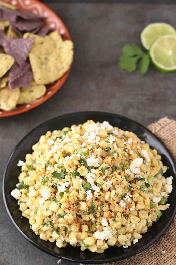 If you're hosting happy hour at home or throwing a tailgate party, you need this Elote Dip on the menu. Just like Mexican Street Corn, but in dip form, this is a 15-minute appetizer. Sautéed corn, cilantro, garlic, chili powder, Cojita, and mayo make the best dip at the party!