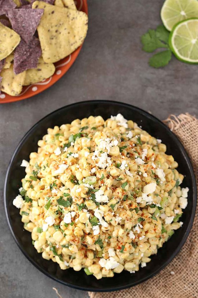 If you're hosting happy hour at home or throwing a tailgate party, you need this Elote Dip on the menu. Just like Mexican Street Corn, but in dip form, this is a 15-minute appetizer. Sautéed corn, cilantro, garlic, chili powder, Cojita, and mayo make the best dip at the party!