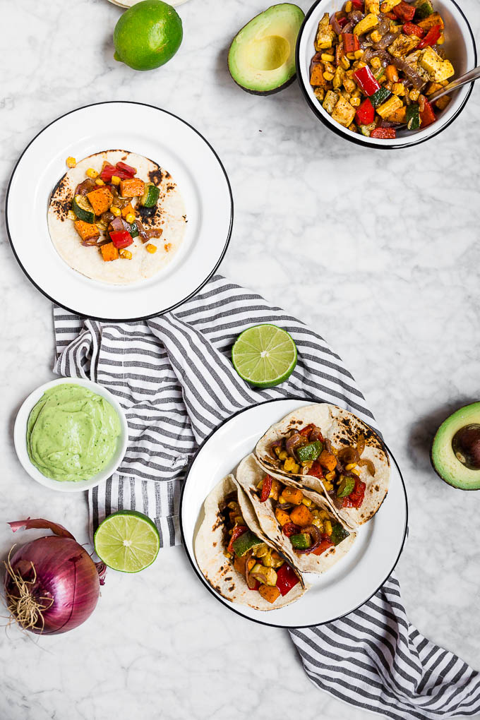 Learn to make these Roasted Veggie Tacos with Avocado Crema like a pro to impress dinner guests. This cheap healthy meal is a vegetarian dinner full of vibrant colors and flavors.