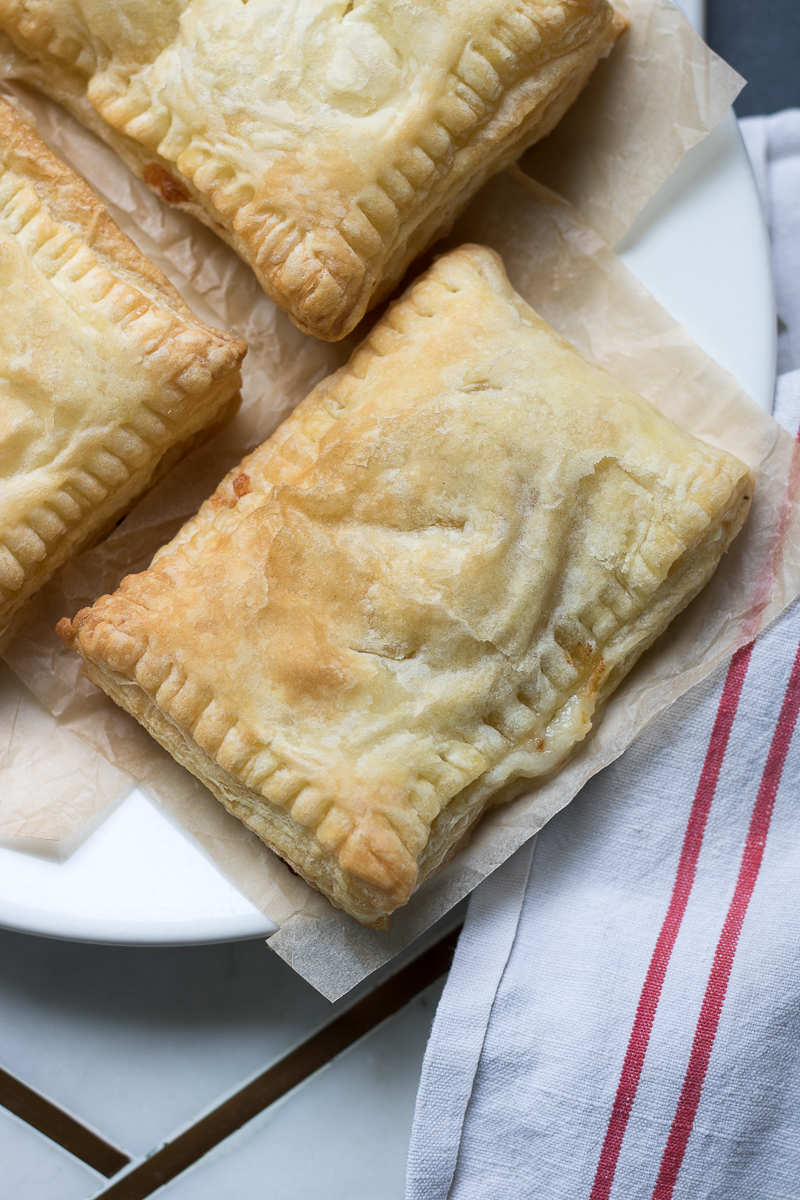 These 3-ingredient Cheesy Ham Puff Pastry Pockets are perfect for easy school lunches or after-school snacks. These tasty hand pies are delicious hot or cold, your kids will love them, and they only take 20 minutes to make!