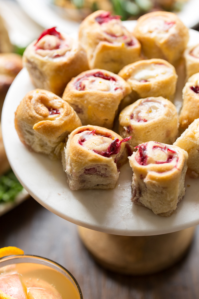Enjoy these super simple Orange Cranberry Mini Sweet Rolls as dessert on your holiday menu, then eat leftovers for breakfast. Full of fall flavors, this mini dessert uses store-bought crescent dough to create small bites for two!