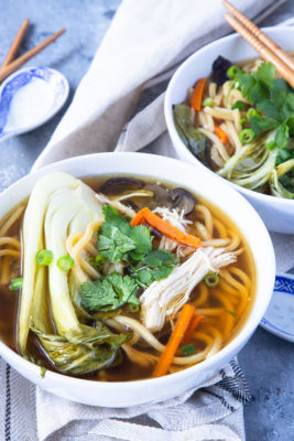 This Slow Cooker Asian Chicken Noodle Soup is what comfort food dreams are made of. An easy weeknight dinner with fall-apart shredded chicken, thick noodles, and fresh veggies. This Crock Pot soup is perfect for the cooler evenings!