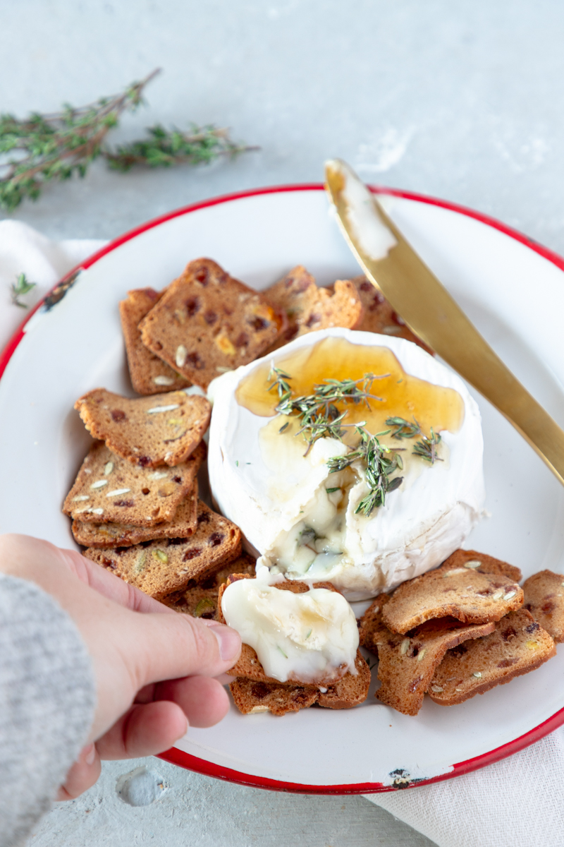 This Honey Thyme Baked Brie Appetizer is perfect for a holiday party, family gathering, or office potluck. This gooey, melty, 3-ingredient appetizer looks so elegant, no one will know it only took you 15 minutes to prepare!