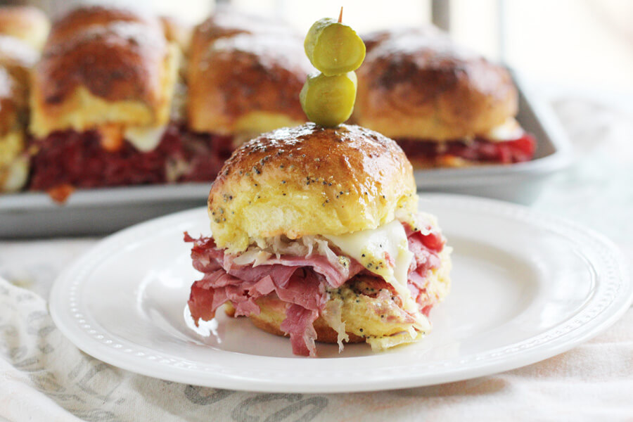 Looking for a hearty, 30-minute appetizer for game day? These Reuben Slider Sandwiches are made with classic corned beef, sauerkraut, cheese, and a zippy sandwich sauce. These mini deli-style sandwiches are an easy appetizer that will impress a crowd!