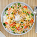 Chicken Hawaiian Haystacks is a 30-minute meal with a rice base topped with chicken gravy, chopped tomatoes, peas, pineapple, chow mein noodles, cheese, and coconut flakes. This budget-friendly dish is a one-pot, 4-person $10 meal that's comfort food at its finest.
