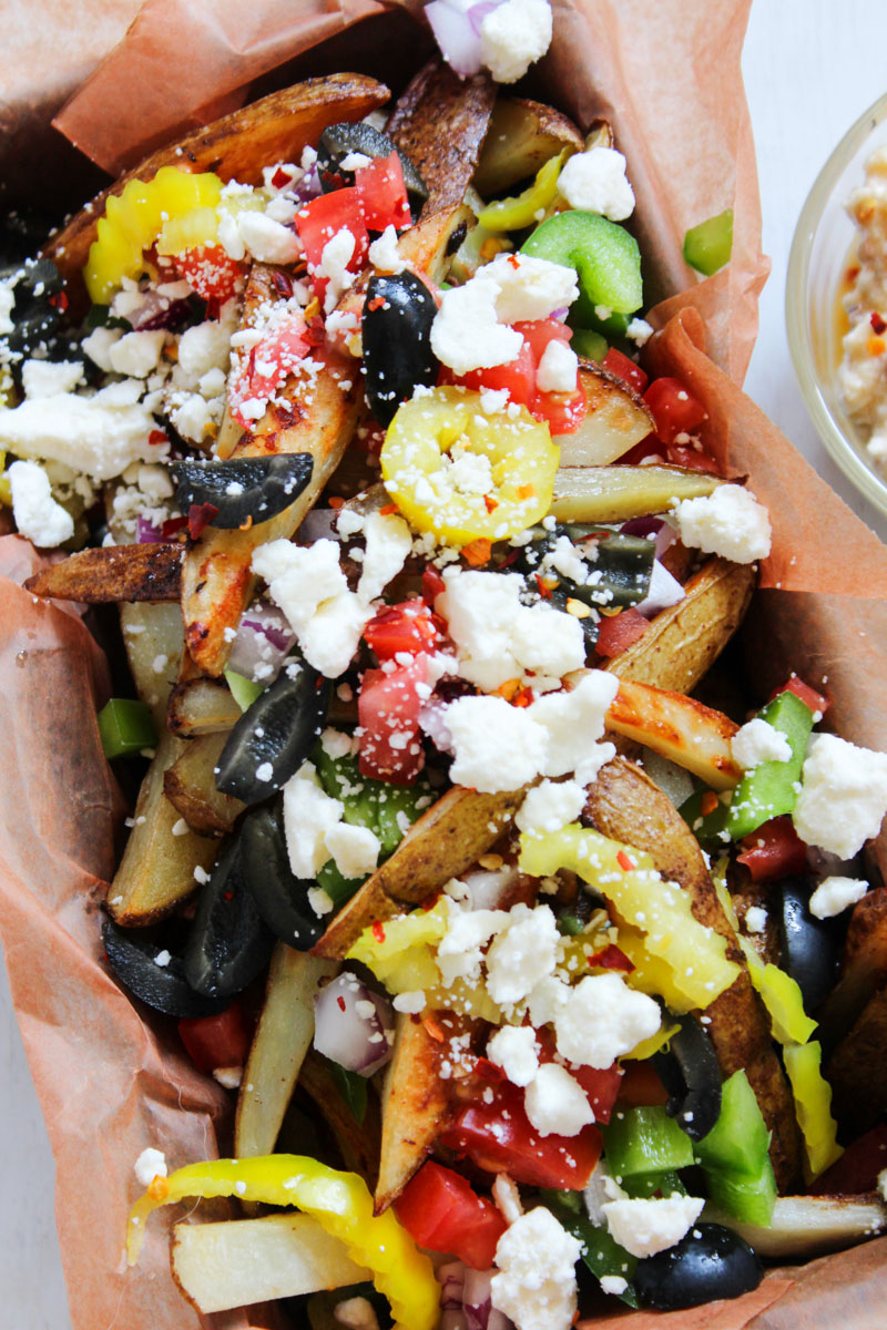 Crispy fries, salty feta, and Mediterranean vegetables are served together in this food truck inspired appetizer with a zesty feta dip. These Loaded Greek Street Fries are perfect for happy hour or anytime you are craving indulgent street food.