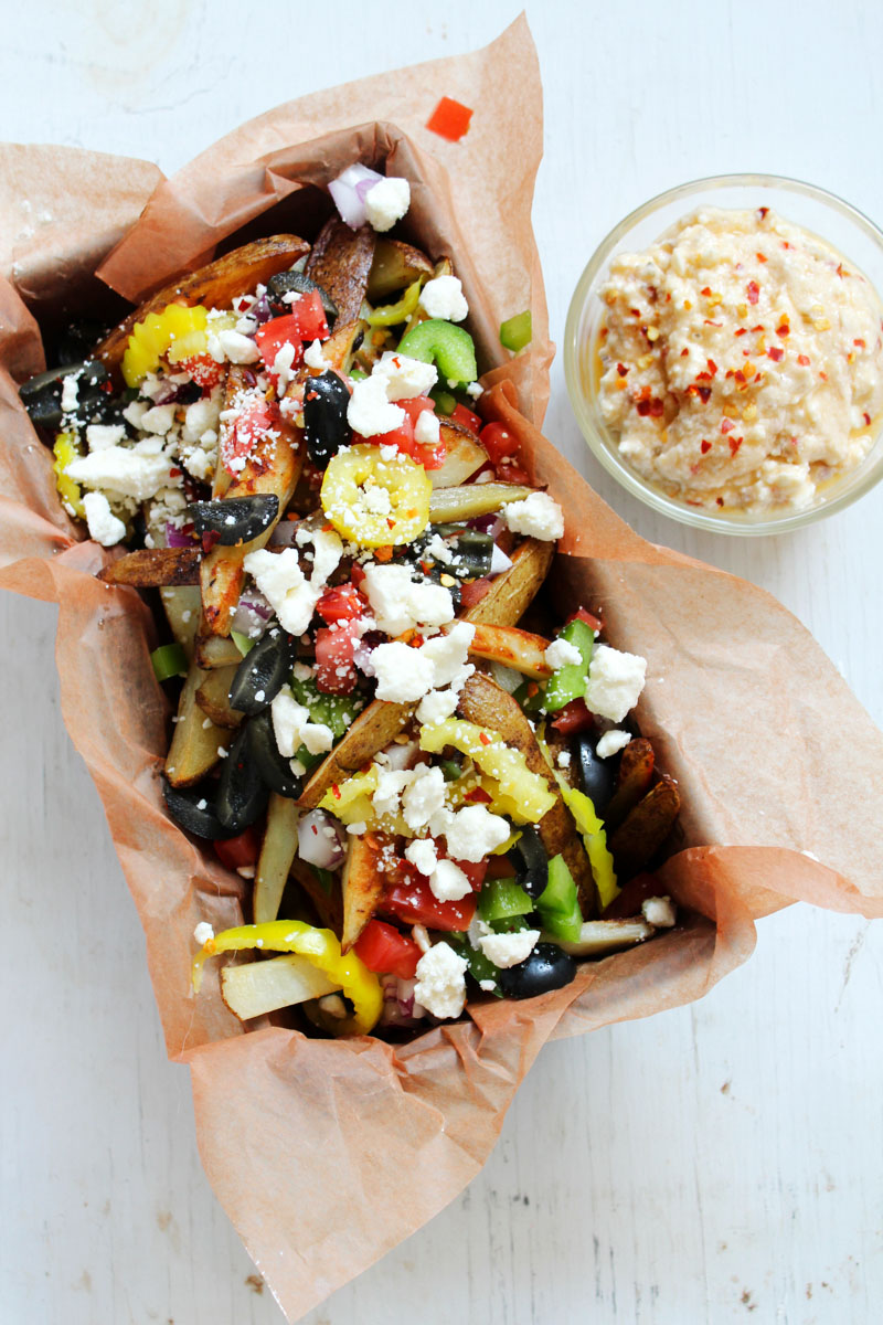 Crispy fries, salty feta, and Mediterranean vegetables are served together in this food truck inspired appetizer with a zesty feta dip. These Loaded Greek Street Fries are perfect for happy hour or anytime you are craving indulgent street food.