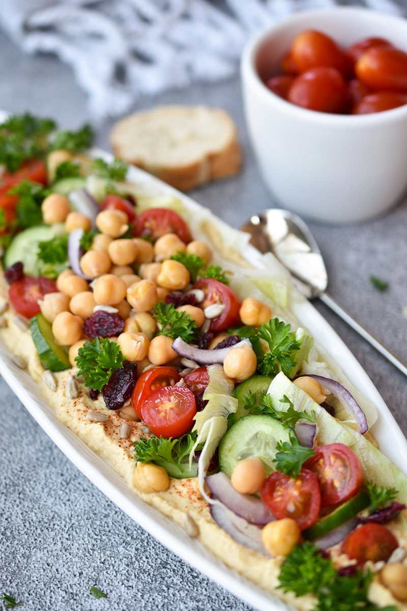 This Farmers Market Loaded Hummus is a guest-worthy appetizer full of vegetables and fruit. This healthy plant-based snack pairs perfectly with crackers or bread and it's an easy appetizer to take along for summer entertaining.