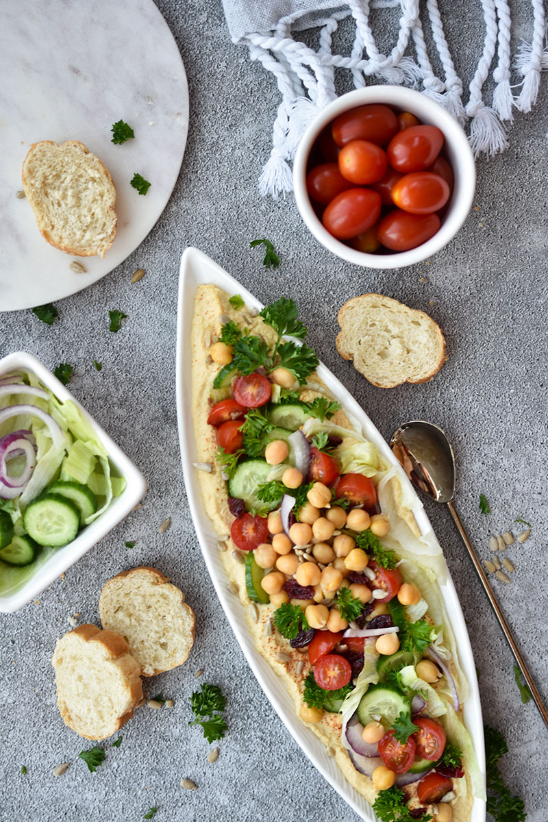 This Farmers Market Loaded Hummus is a guest-worthy appetizer full of vegetables and fruit. This healthy plant-based snack pairs perfectly with crackers or bread and it's an easy appetizer to take along for summer entertaining.