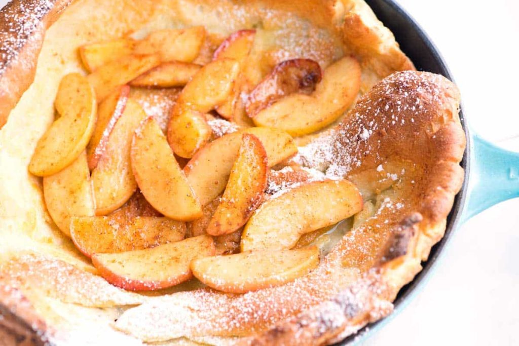 An Apple Dutch Baby Pancake is a large pancake baked in a cast iron skillet in a hot oven. Tender in the center and crispy on the outside, this delicious breakfast or Sunday brunch recipe is filled with warm spiced apples, cinnamon, and cardamom.
