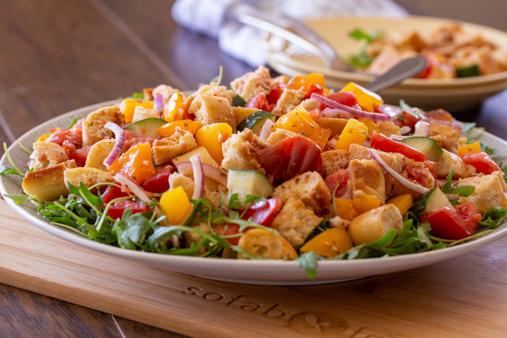 Classic Italian Tuscan Panzanella Bread Salad is made with cubes of crusty bread, farmers market fresh ripe tomatoes, cucumbers, red onions, and basil. All tossed in a fragrant basil pesto vinaigrette.