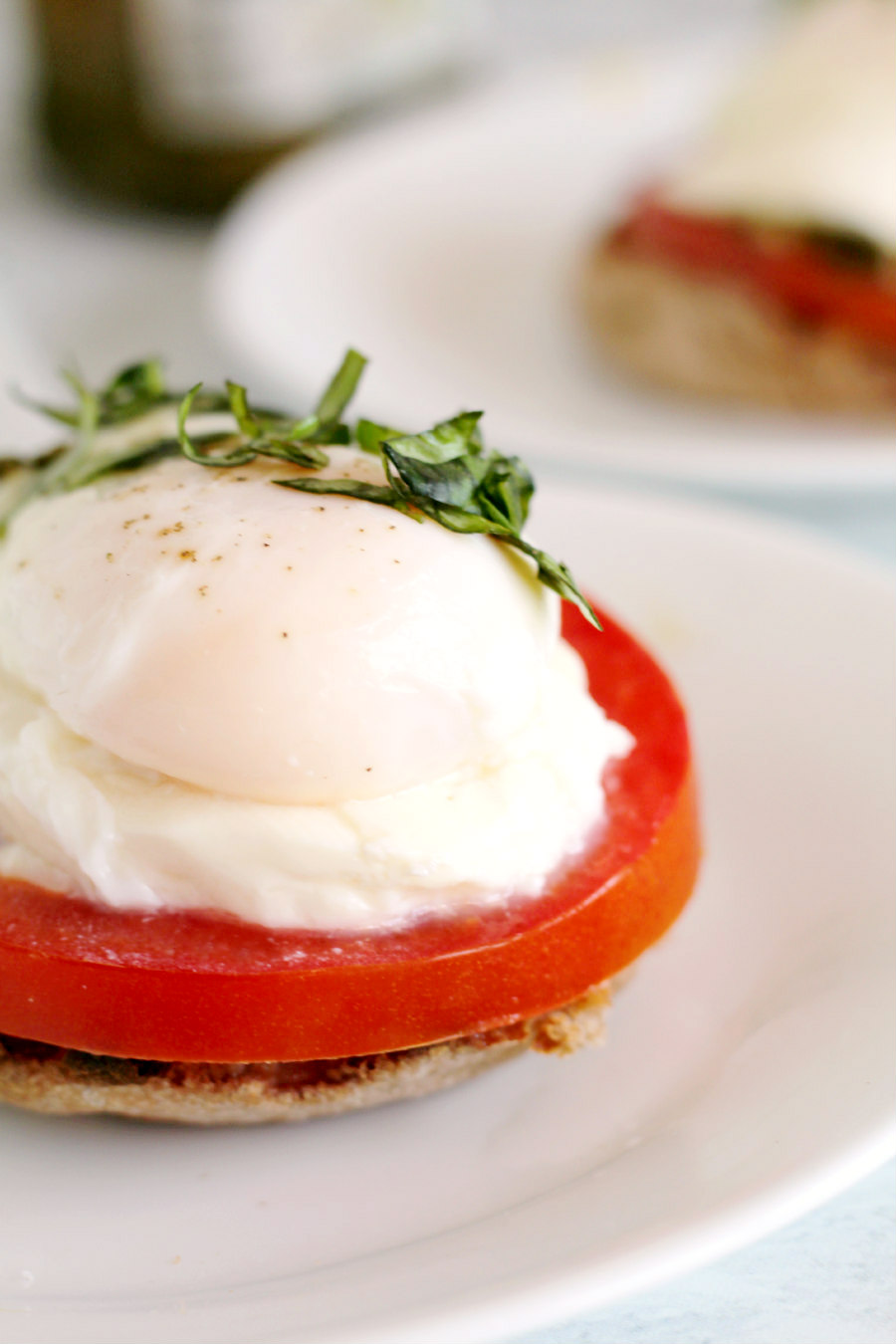 If you enjoy the traditional Italian flavors of Caprese Salad, you'll love this Poached Eggs Caprese recipe. Poached eggs on English muffins with tomato, basil, pesto, and fresh mozzarella for a hearty breakfast or Sunday brunch!