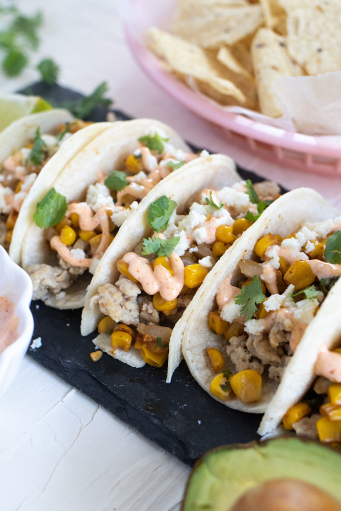 Enjoy the flavors of Mexican Elote with these simple Mexican Street Corn Chicken Tacos instead of traditional tacos. Roasted corn, spicy mayo dressing, lime juice, and your favorite taco toppings for the perfect weeknight meal.
